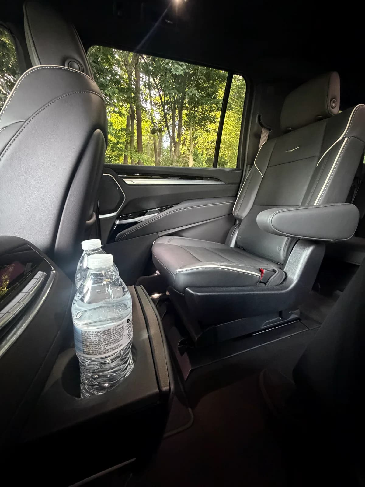 Captain's chair and bottled water inside an AZA Cadillac Escalade