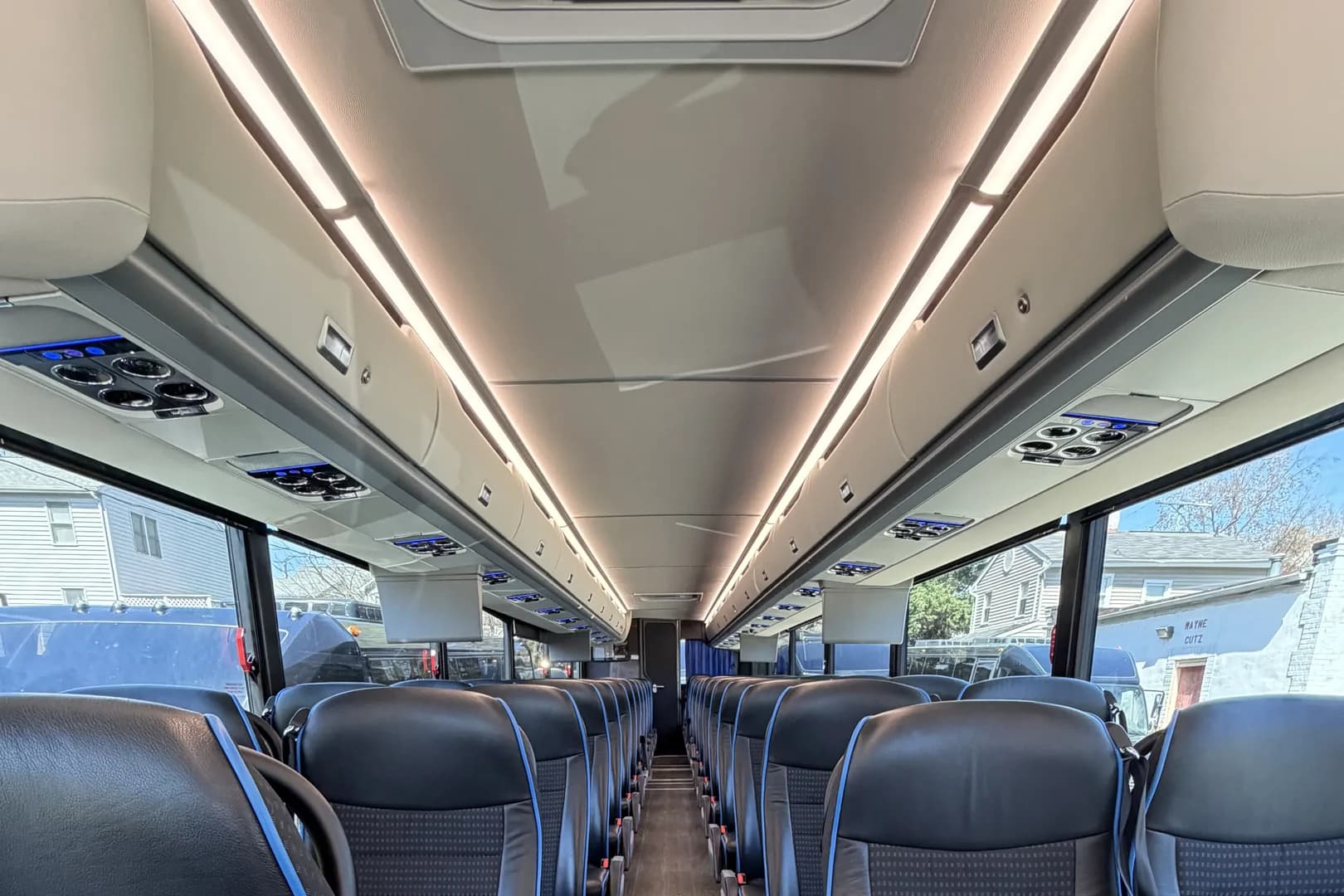 Rows of seats inside an AZA coach bus, with room to settle in