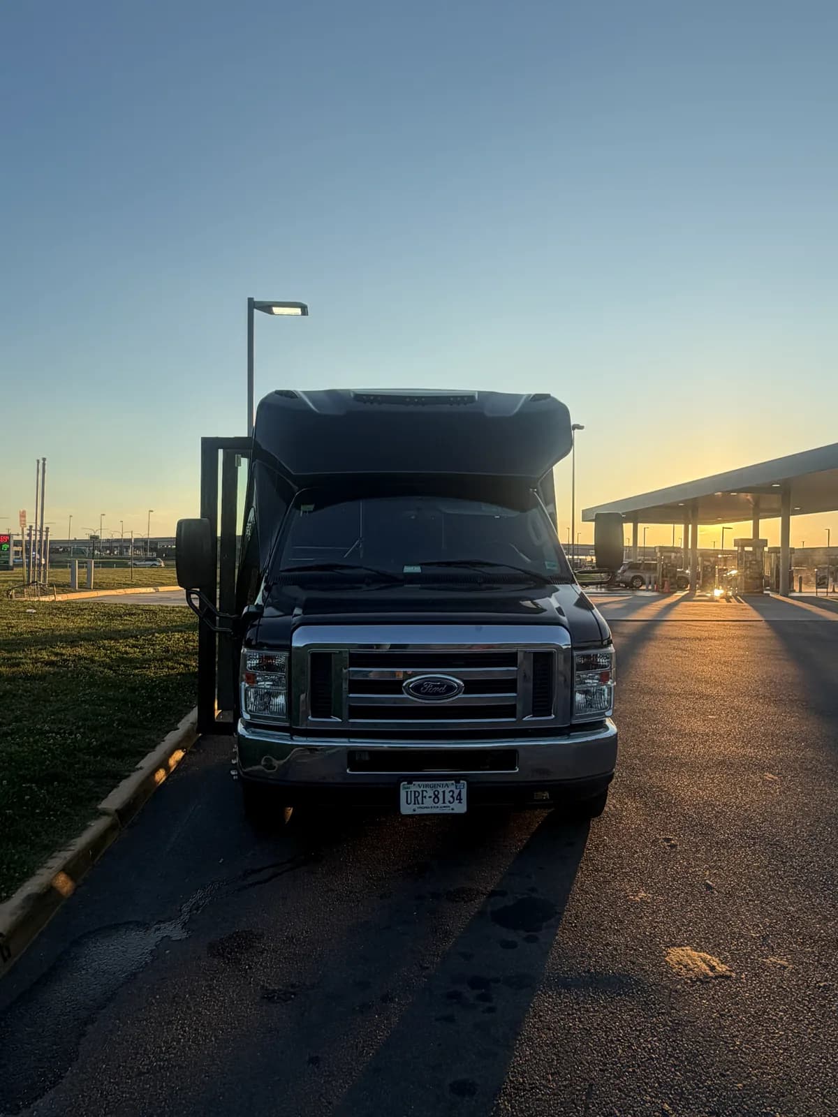 AZA Ford E450 shuttle bus parked at sunset