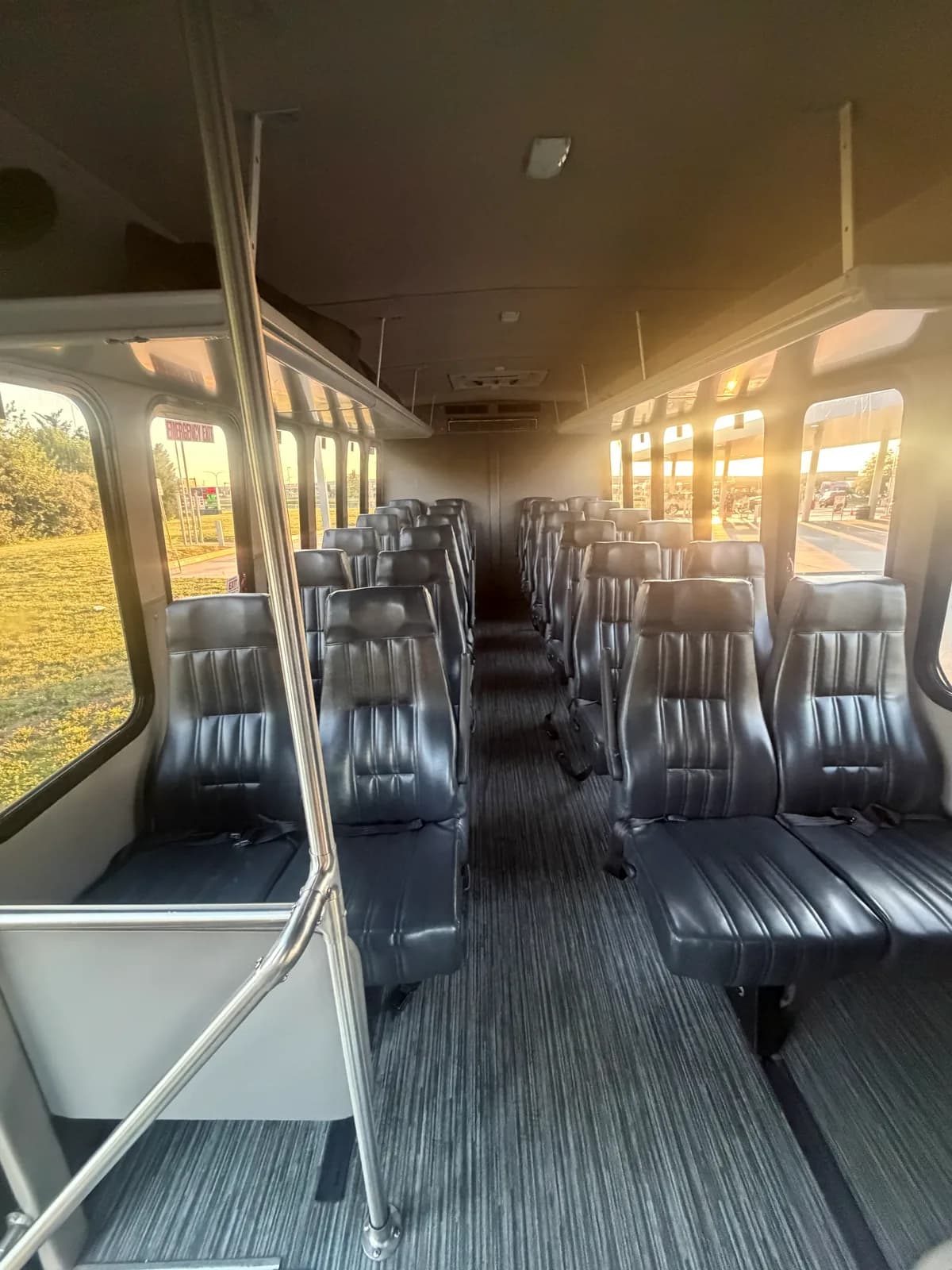 Interior aisle of an AZA Ford E450 shuttle lit by warm afternoon sun