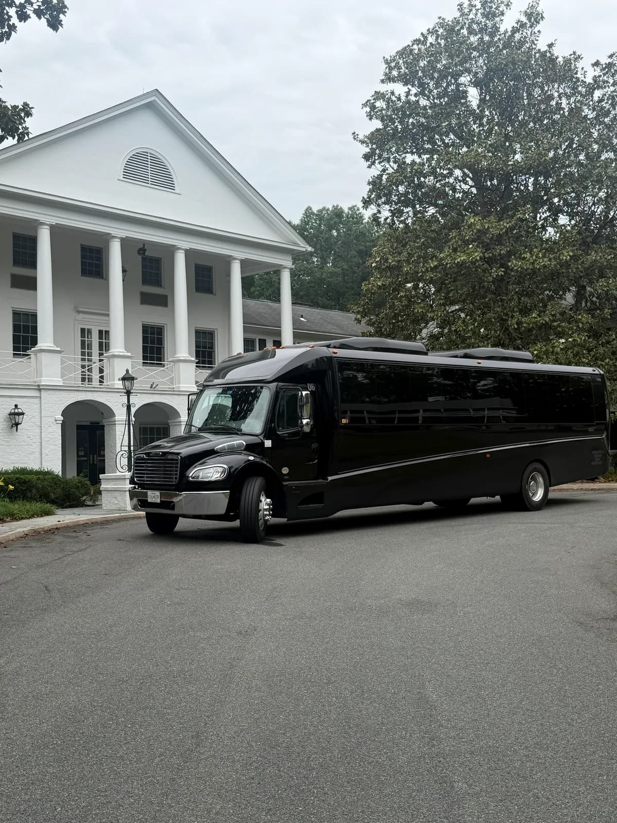 AZA GM40 bus parked near a colonial-style building