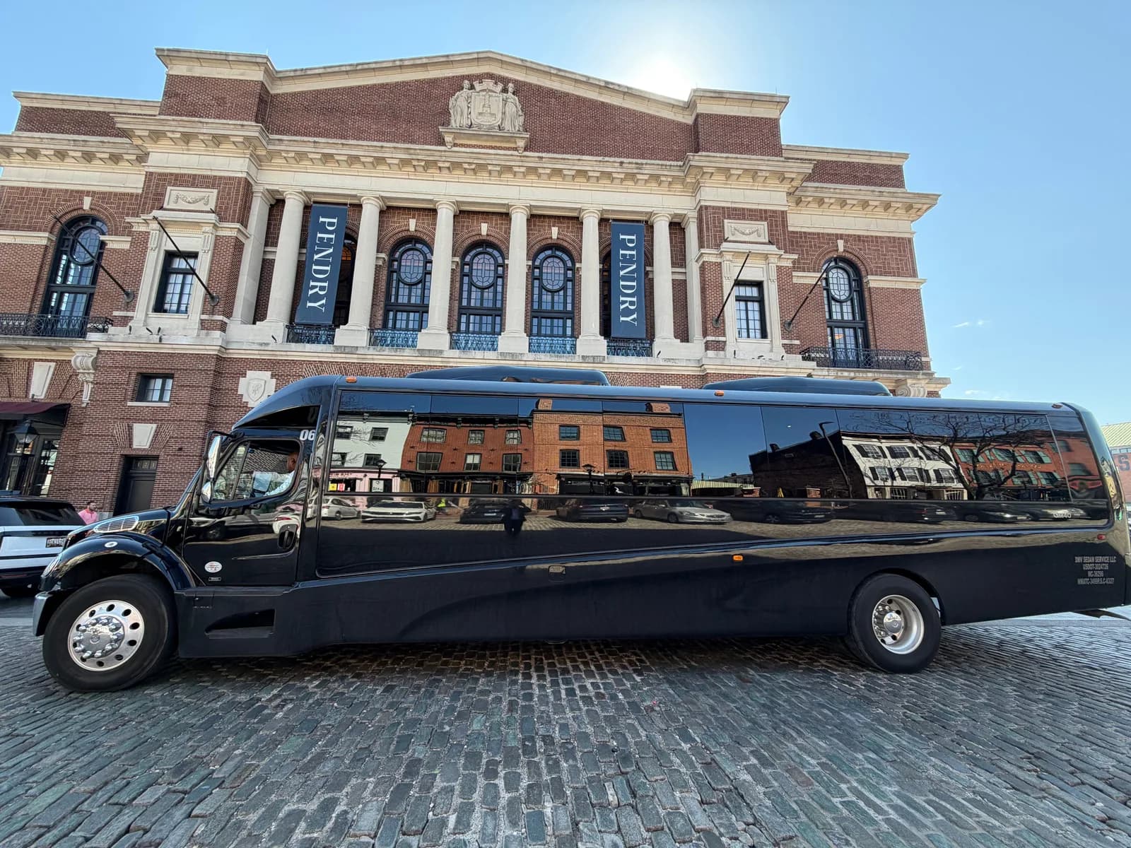 AZA GM40 bus parked in front of a historic concert hall