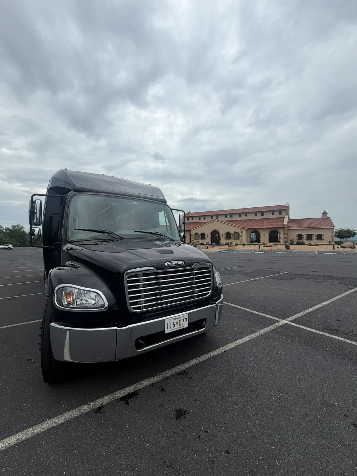 AZA GM40 bus parked near a Mediterranean-style venue building