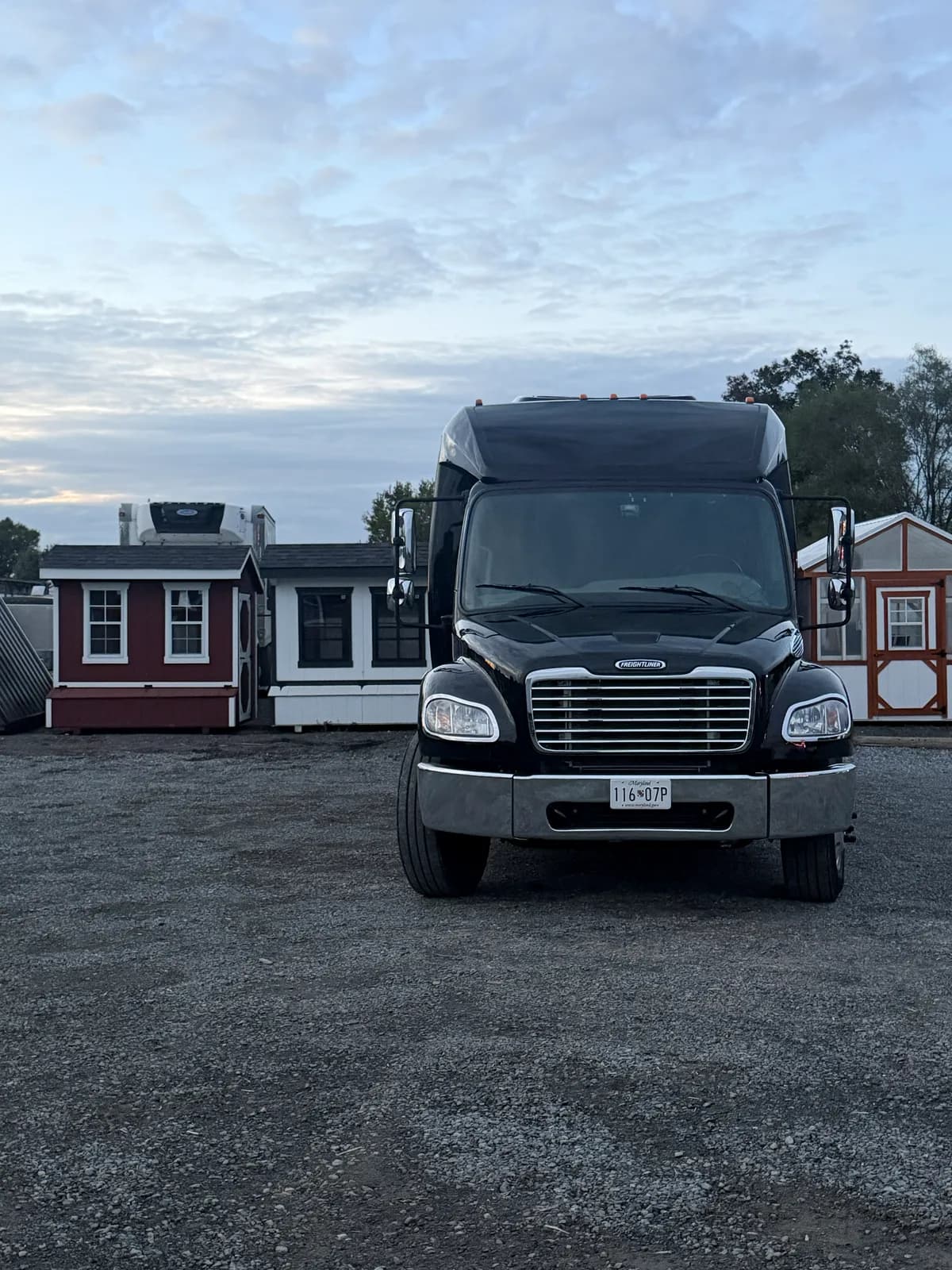 AZA GM40 bus parked near storage buildings under an overcast sky