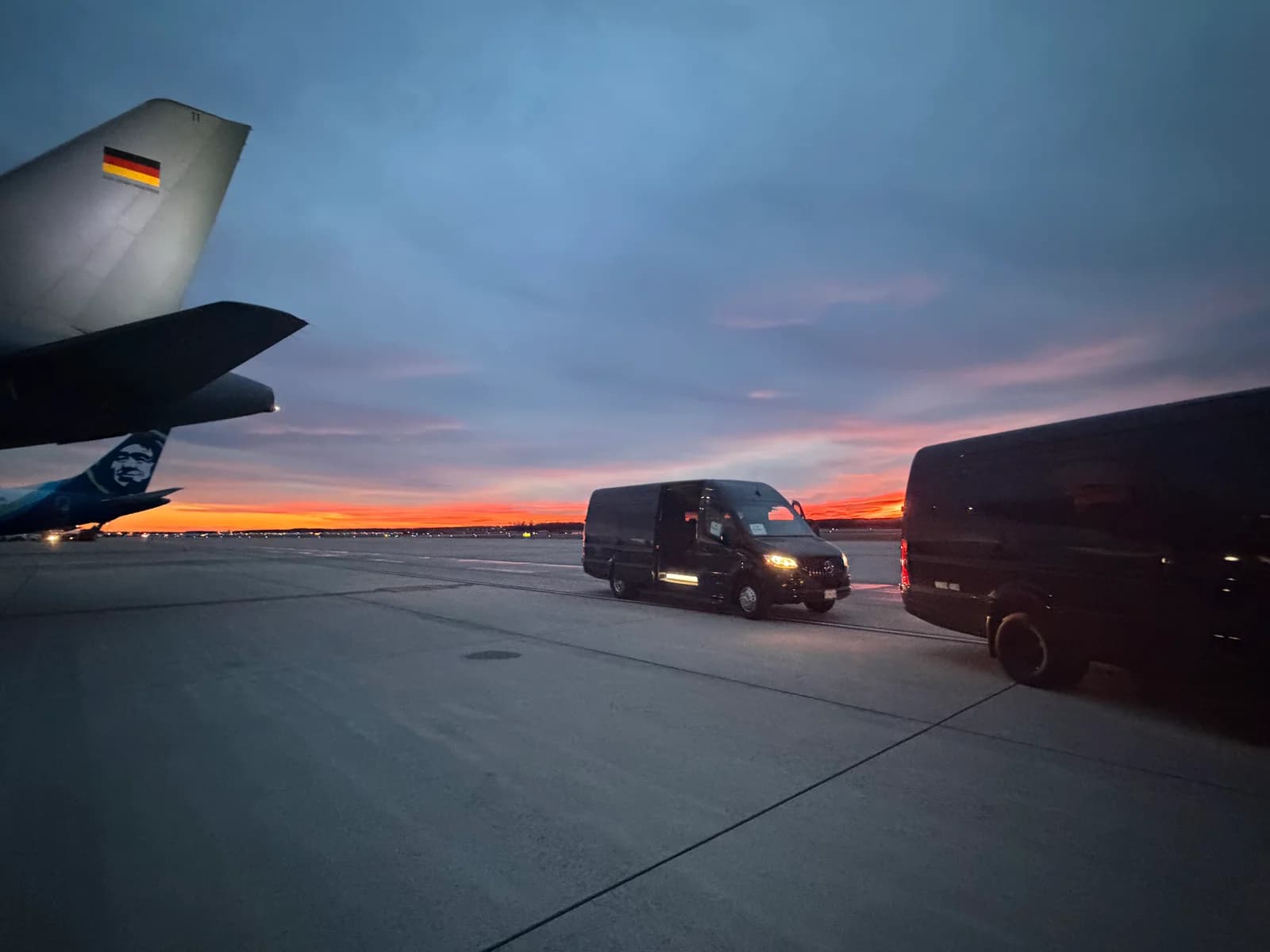 AZA Sprinter vans on the tarmac at sunset for an airport transfer